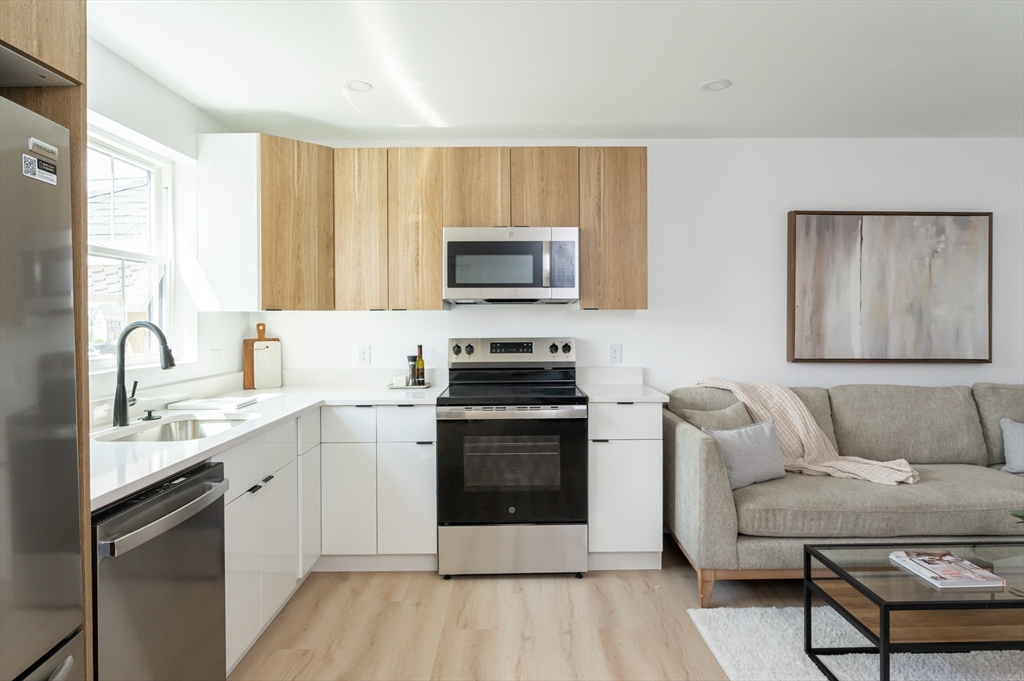 7 Kenoza Avenue, Unit 101 Haverhill, MA 01830 - Photo 2 of 21 a kitchen with stainless steel appliances a stove a sink a microwave and a refrigerator