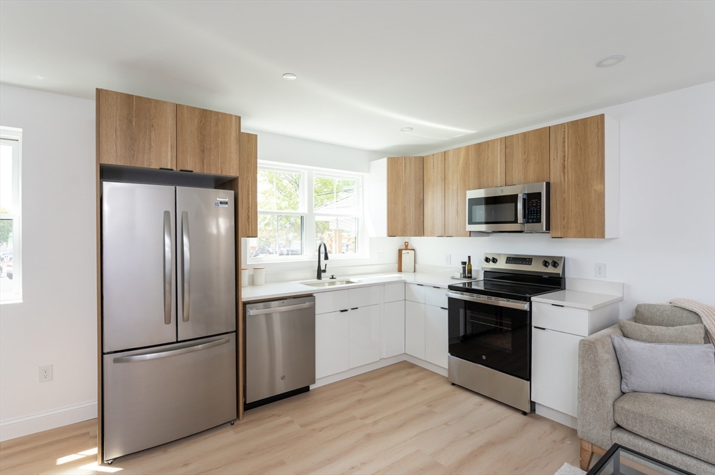 7 Kenoza Avenue, Unit 101 Haverhill, MA 01830 - Photo 3 of 21 a kitchen with stainless steel appliances granite countertop a refrigerator stove microwave and sink