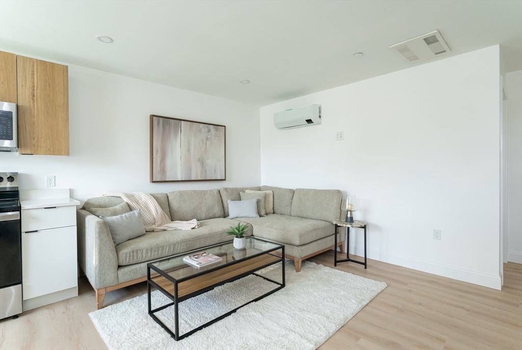 7 Kenoza Avenue, Unit 101 Haverhill, MA 01830 - Photo 7 of 21 a living room with furniture and a wooden floor