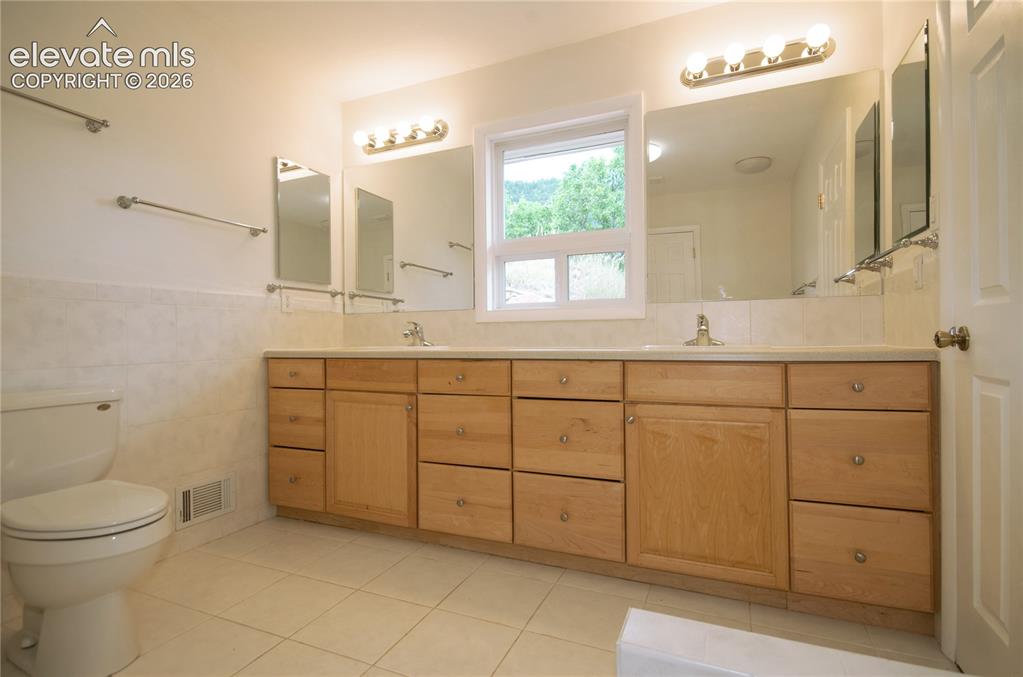 4710 Limestone Road Monument, CO 80132 - Photo 30 of 50 a bathroom with a toilet sink and mirror