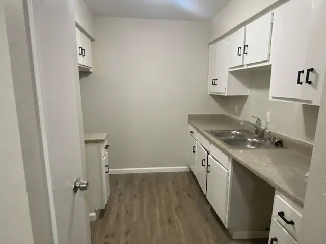 a kitchen with granite countertop a sink stove and cabinets