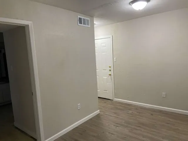a view of an empty room with wooden floor