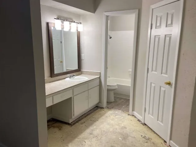 a bathroom with a double vanity sink toilet and shower