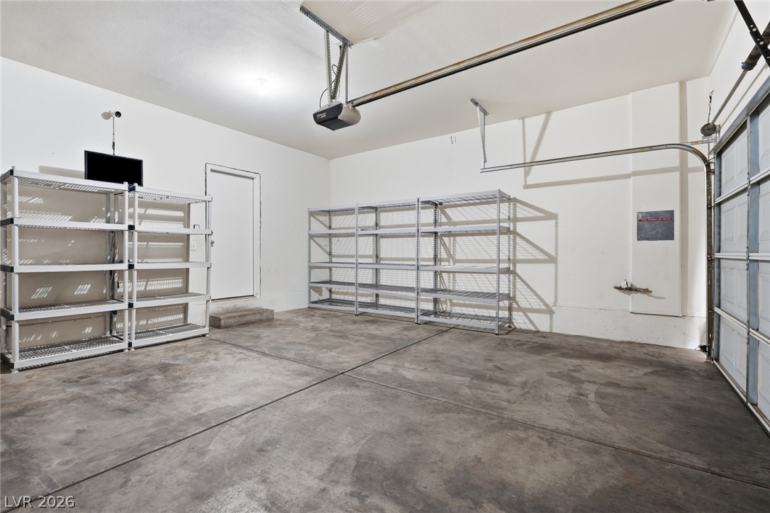 8932 Caledon Ridge Court Las Vegas, NV 89149 - Photo 35 of 39 A spacious garage features durable concrete flooring, smooth walls, and convenient automatic door tracks.