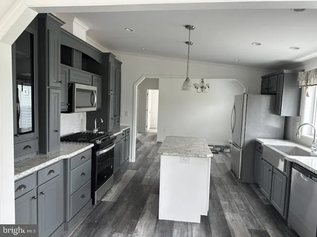 a kitchen with stainless steel appliances granite countertop a sink a stove and a refrigerator