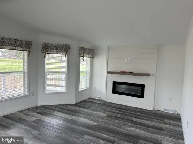 a view of an empty room with a fireplace and a window
