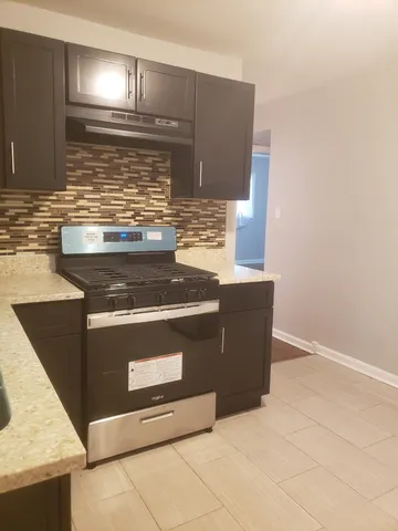 a stove top oven sitting inside of a kitchen