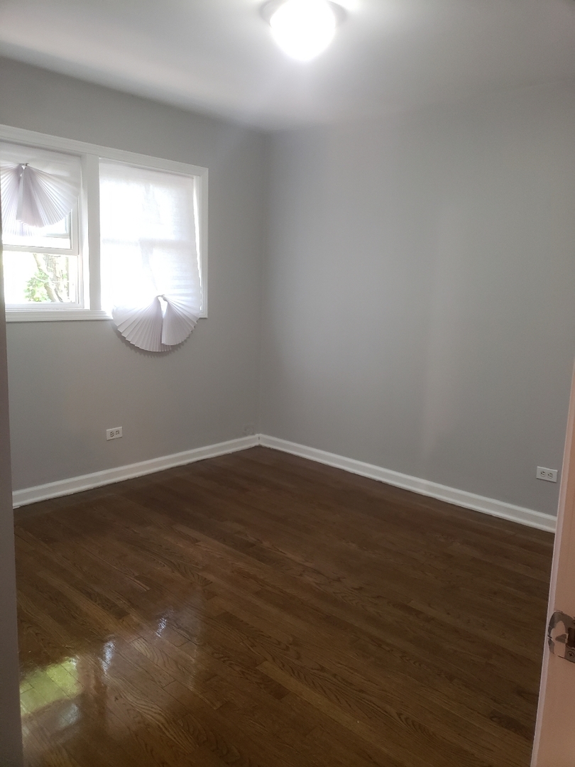 1061 East 80th Street, Unit 2N Chicago, IL 60619 - Photo 5 of 8 a view of wooden floor and windows in a room