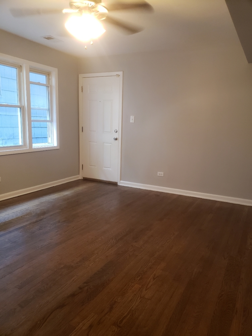 1061 East 80th Street, Unit 2N Chicago, IL 60619 - Photo 8 of 8 an empty room with wooden floor and windows