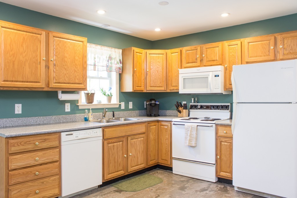 49 Duval Road Sutton, MA 01590 - Photo 12 of 27 a kitchen with a refrigerator a stove a sink and cabinets