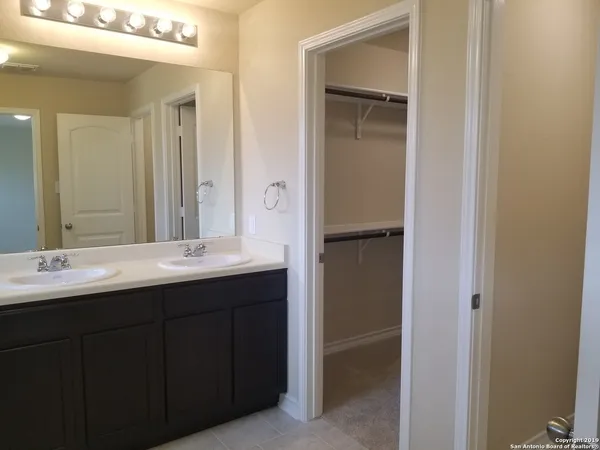 a bathroom with a double vanity sink and a mirror