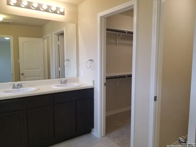 a bathroom with a double vanity sink and a mirror
