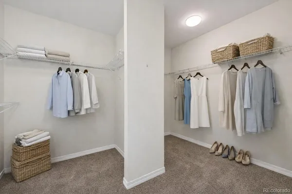 a view of walk in closet with clothes