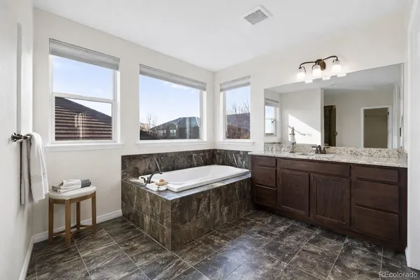 a spacious bathroom with a tub sink and mirror