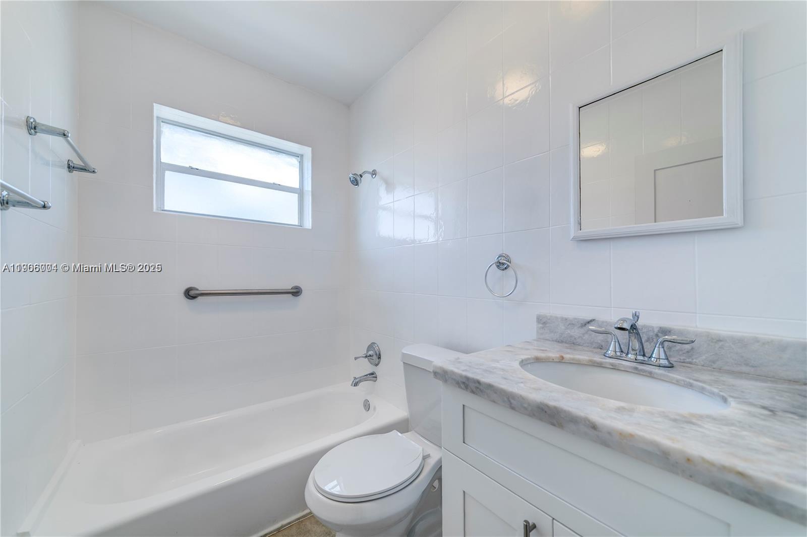 7975 Crespi Boulevard, Unit 1 Miami Beach, FL 33141 - Photo 14 of 21 a bathroom with a granite countertop sink a toilet and shower