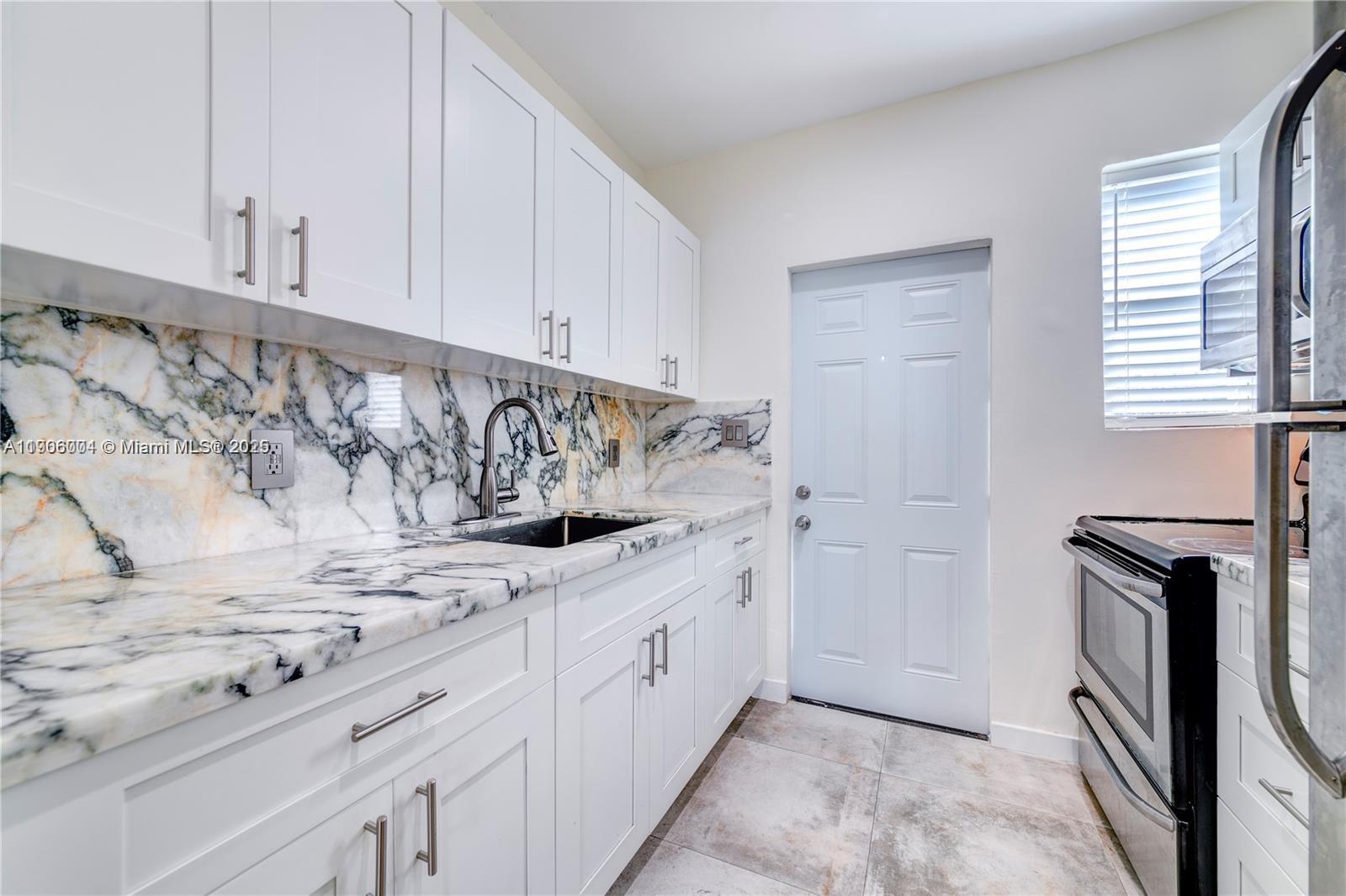 7975 Crespi Boulevard, Unit 1 Miami Beach, FL 33141 - Photo 7 of 21 a bathroom with a sink and a mirror