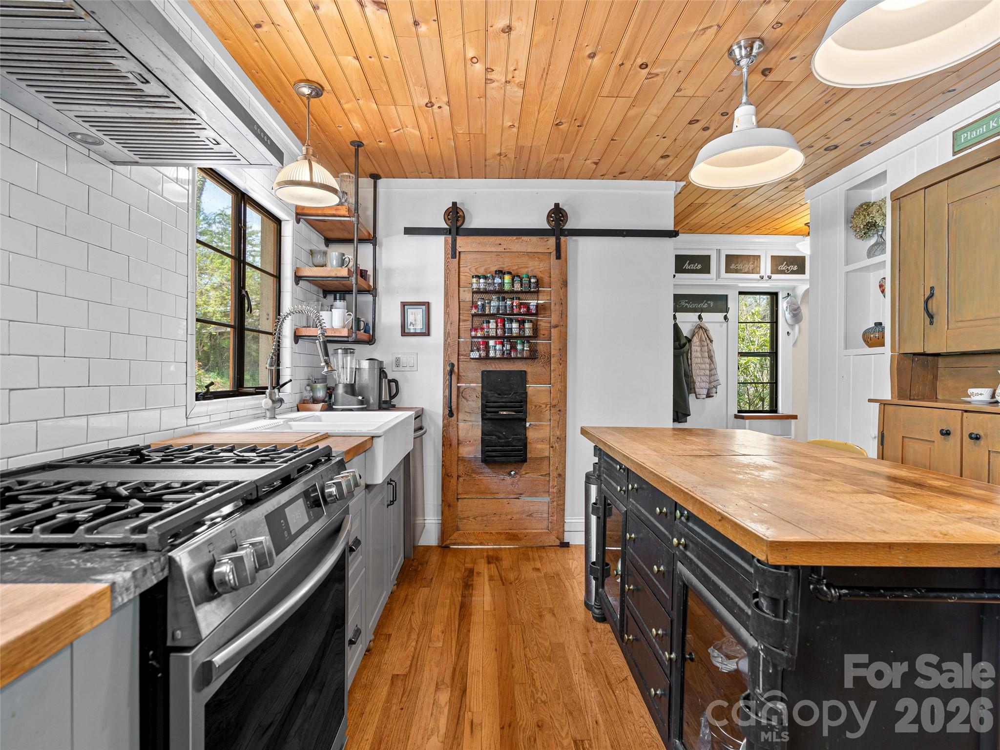 686 New Haw Creek Road Asheville, NC 28805 - Photo 19 of 47 a kitchen with stainless steel appliances granite countertop a large stove a sink dishwasher and cabinets with wooden floor