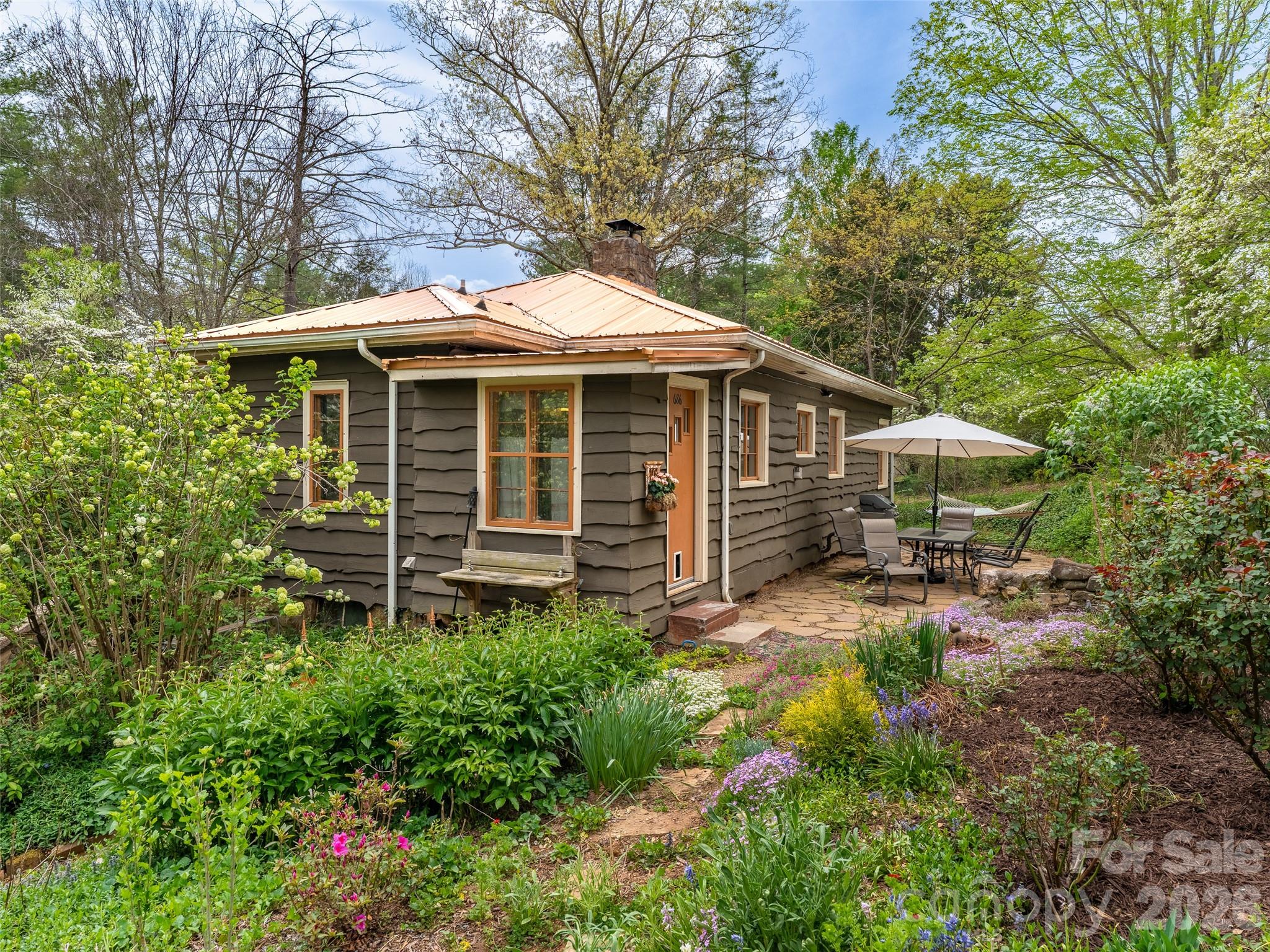 686 New Haw Creek Road Asheville, NC 28805 - Photo 3 of 47 a view of a house with a small yard plants and large trees