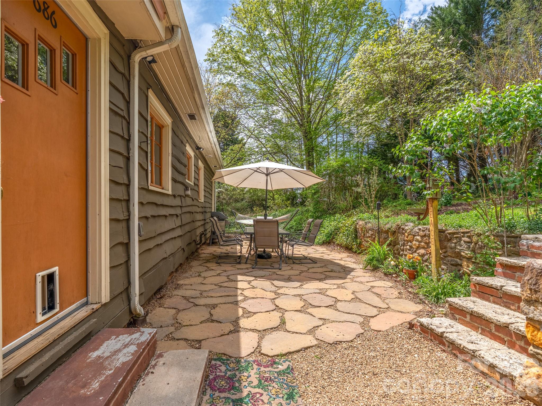 686 New Haw Creek Road Asheville, NC 28805 - Photo 34 of 47 a backyard of a house with table and chairs