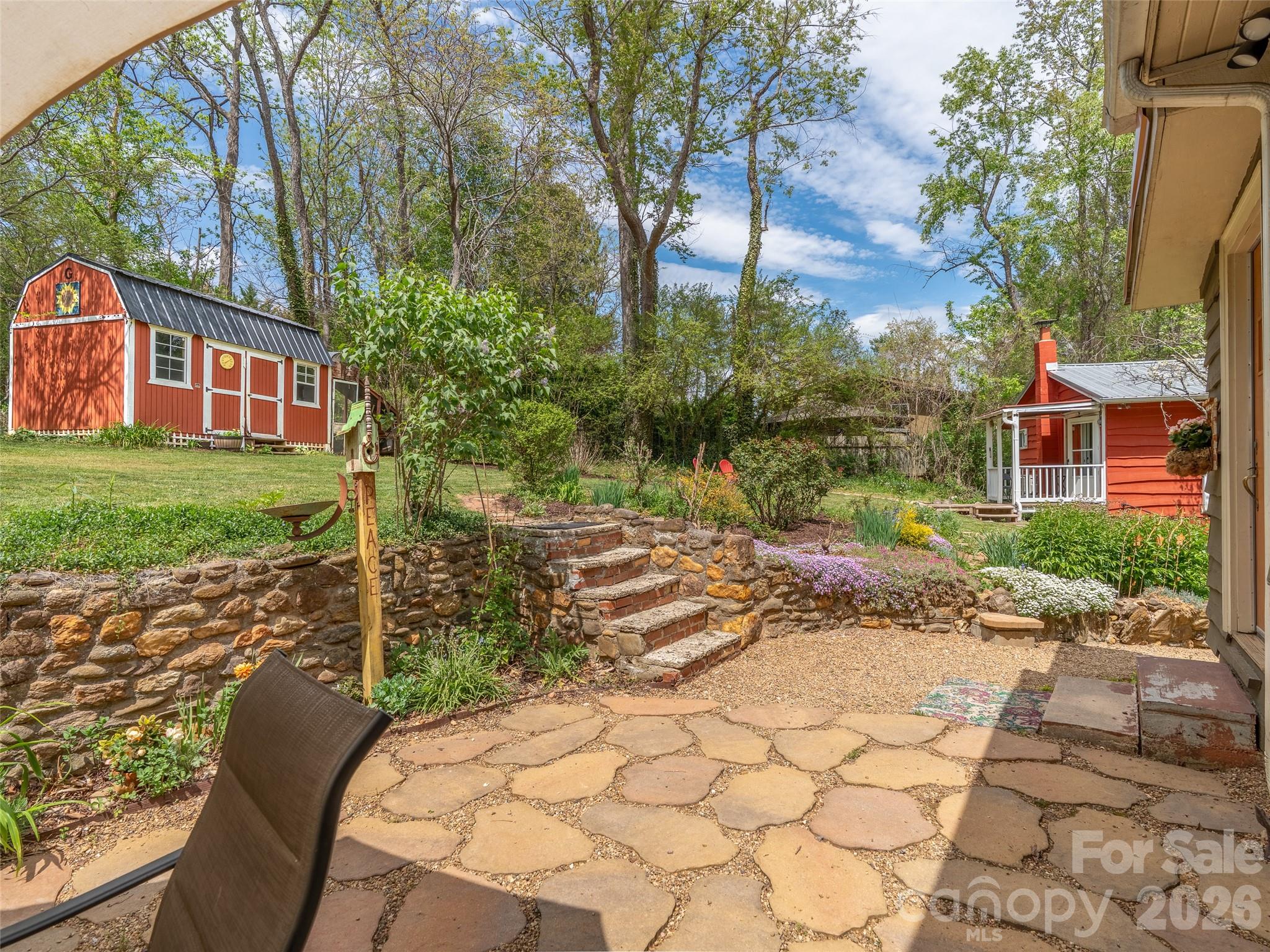 686 New Haw Creek Road Asheville, NC 28805 - Photo 36 of 47 a view of a yard with plants and a barbeque grill