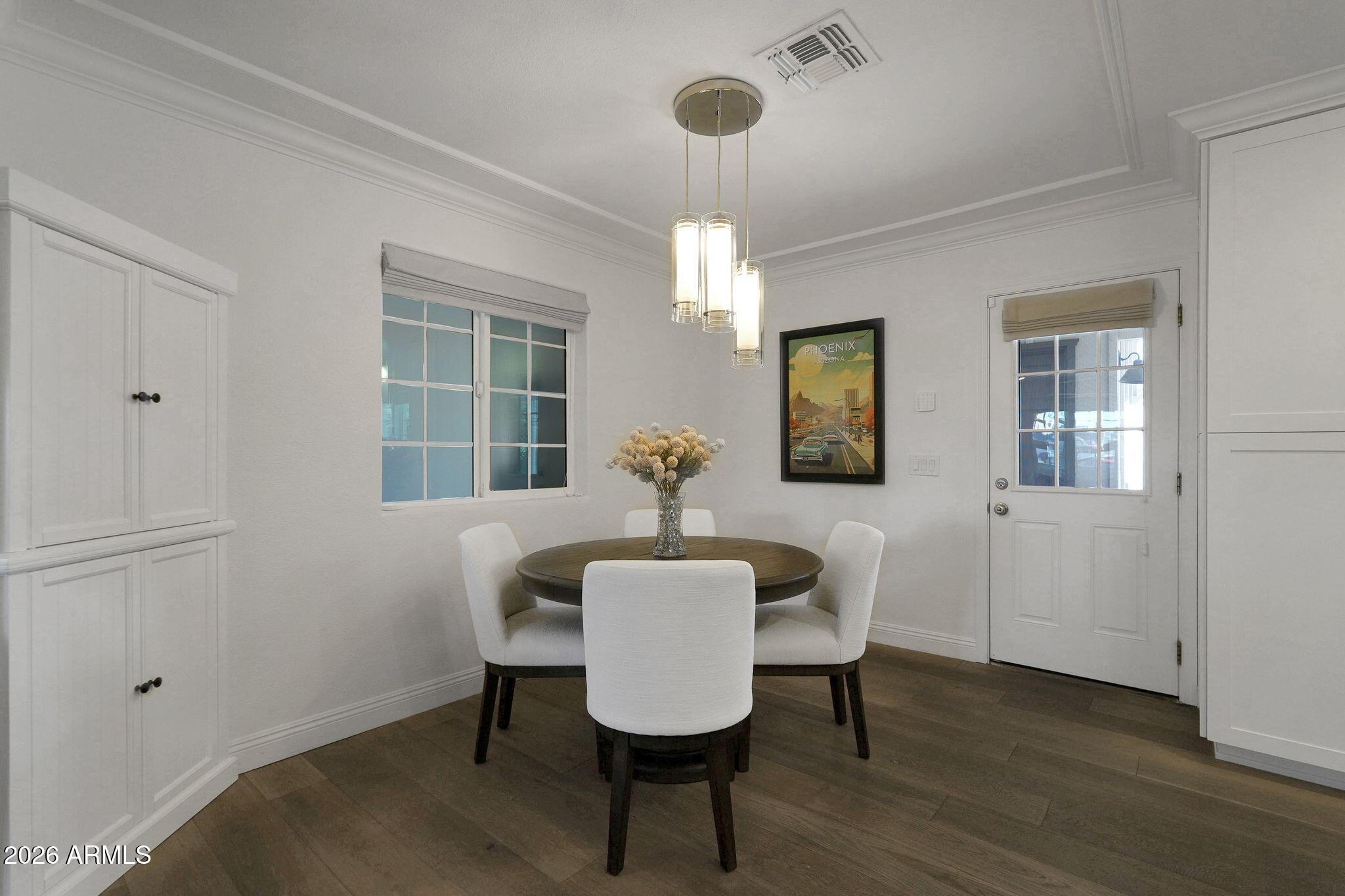 5019 North 2nd Street Phoenix, AZ 85012 - Photo 13 of 30 a dining room with wooden floor a chandelier a glass table and chairs