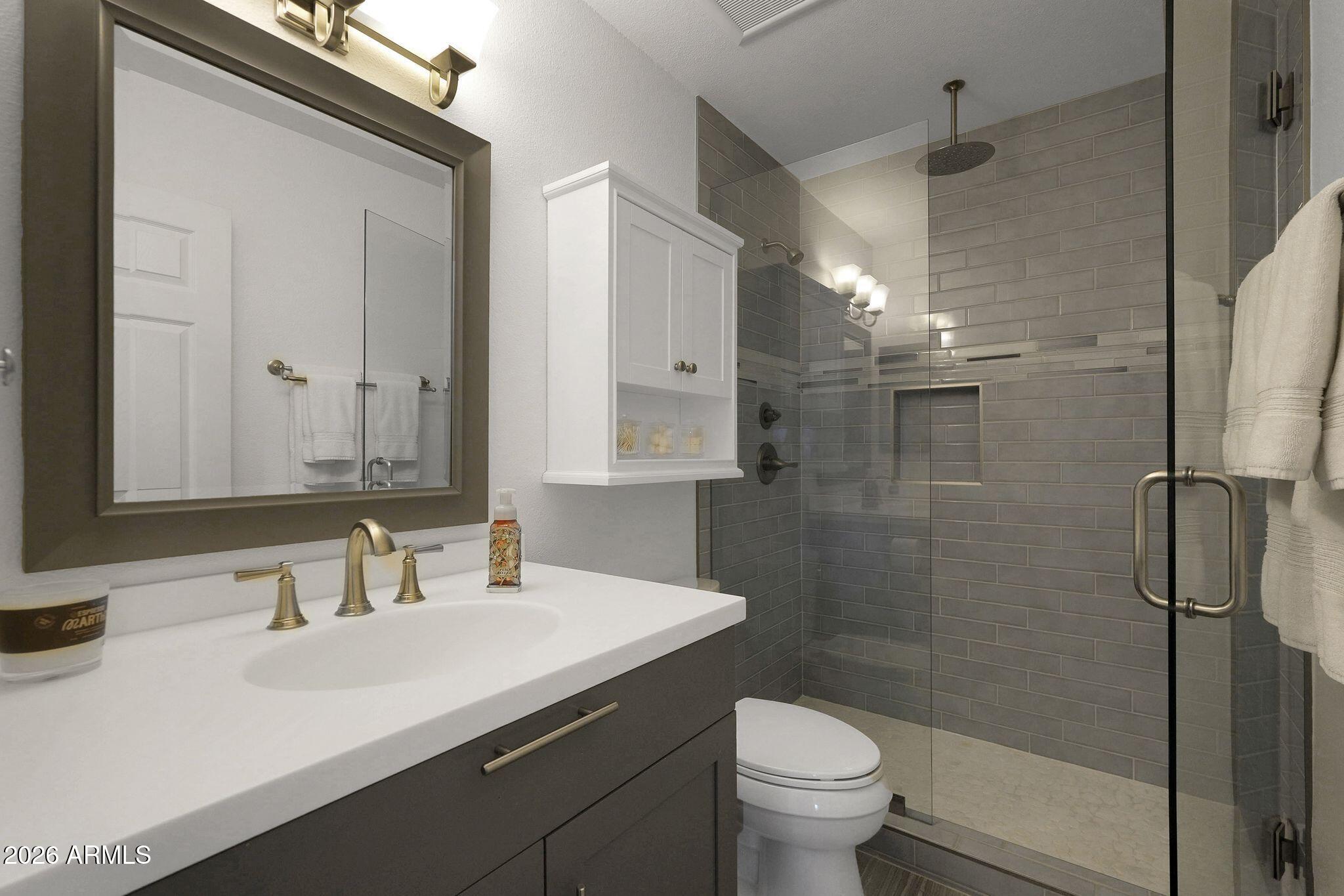5019 North 2nd Street Phoenix, AZ 85012 - Photo 21 of 30 a bathroom with a sink toilet a mirror and shower