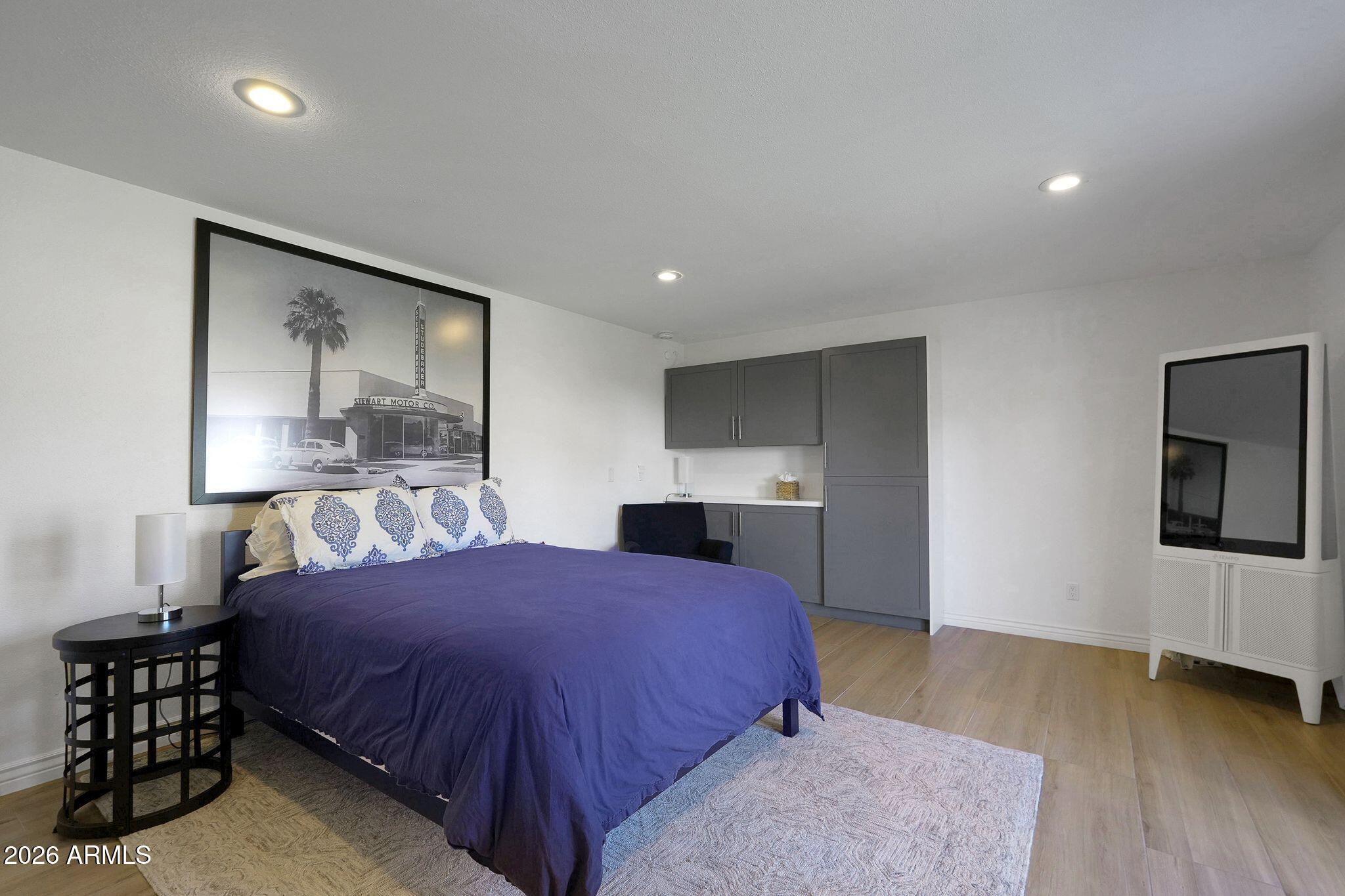 5019 North 2nd Street Phoenix, AZ 85012 - Photo 23 of 30 a spacious bedroom with a bed and a flat tv screen on the dresser