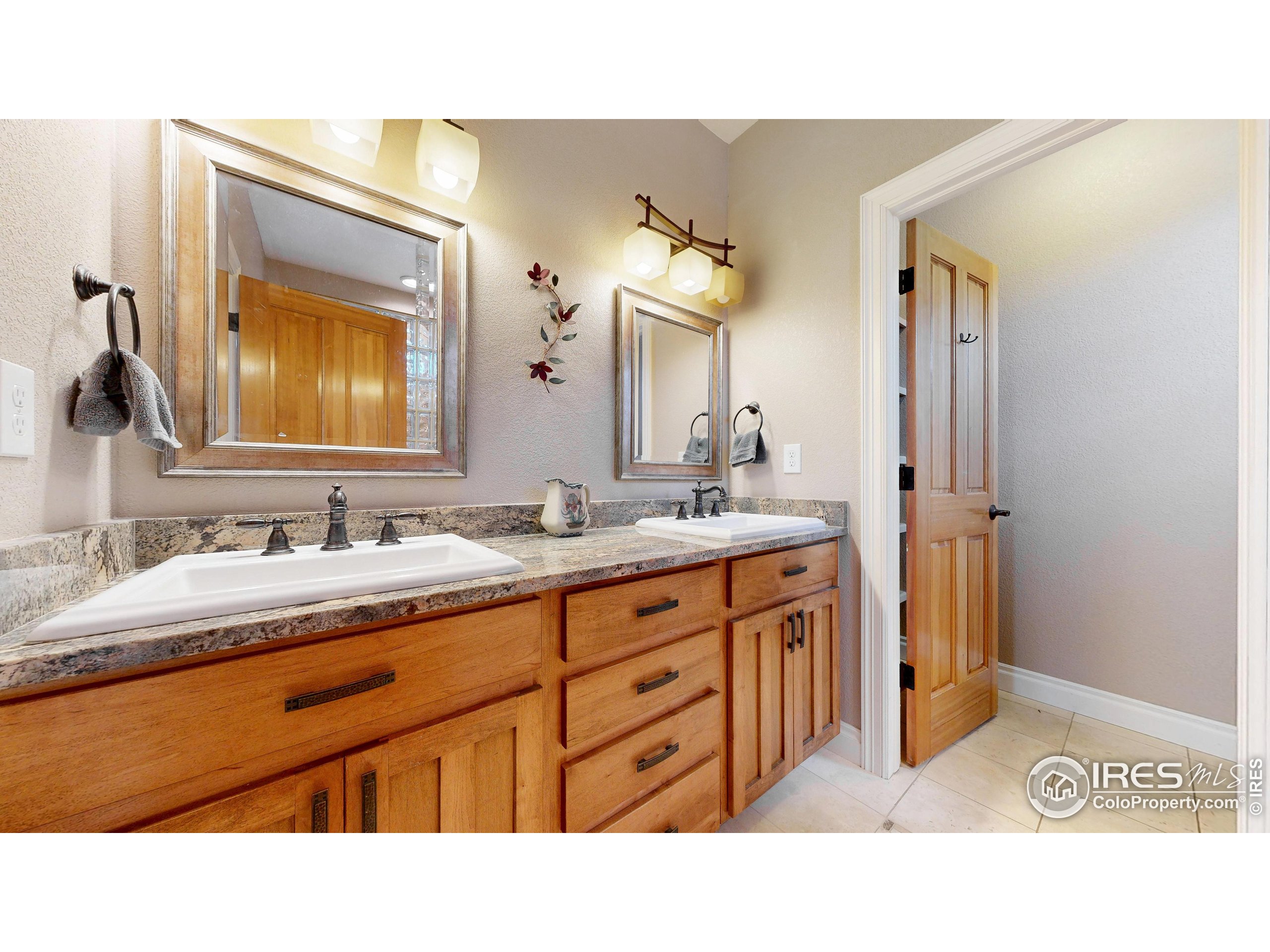 3602 Doral Place Longmont, CO 80503 - Photo 16 of 40 a bathroom with a sink double vanity granite and a mirror