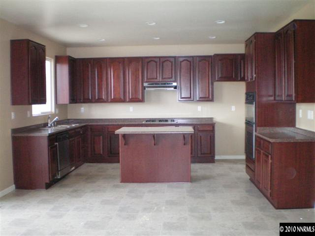 10895 Dancing Aspen Drive Reno, NV 89521 - Photo 5 of 9 a kitchen with stainless steel appliances granite countertop a stove a sink dishwasher a refrigerator and wooden cabinets