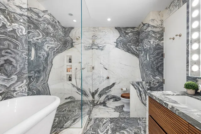 a bathroom with a granite countertop bathtub sink and toilet
