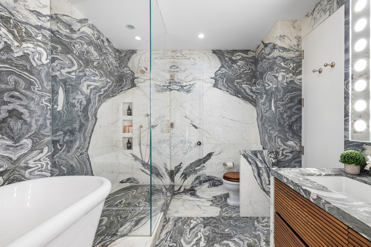 310 East 53rd Street, Unit 21C Manhattan, NY 10022 - Photo 12 of 19 a bathroom with a granite countertop bathtub sink and toilet