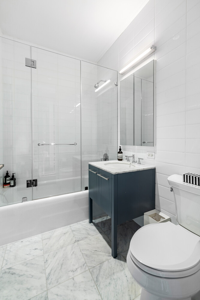 310 East 53rd Street, Unit 21C Manhattan, NY 10022 - Photo 18 of 19 a bathroom with a sink a toilet and bathtub