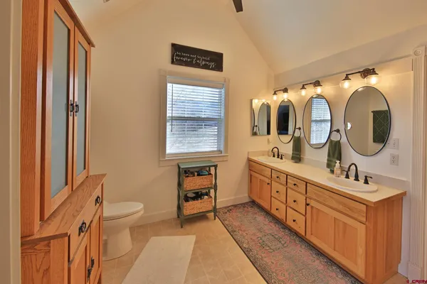 a bathroom with a double vanity sink toilet mirror and tub