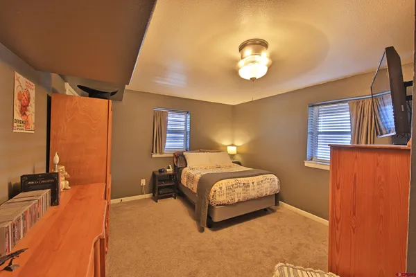 a spacious bedroom with a bed and a chandelier