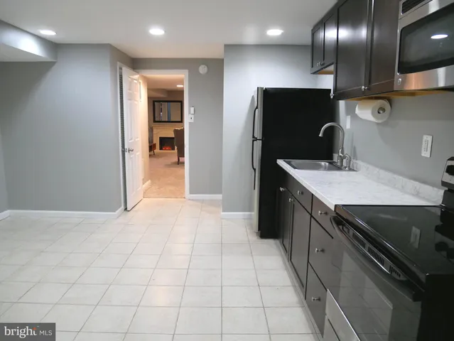 a kitchen with stainless steel appliances granite countertop a sink and a refrigerator