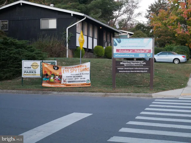 a view of a house with a yard and parking