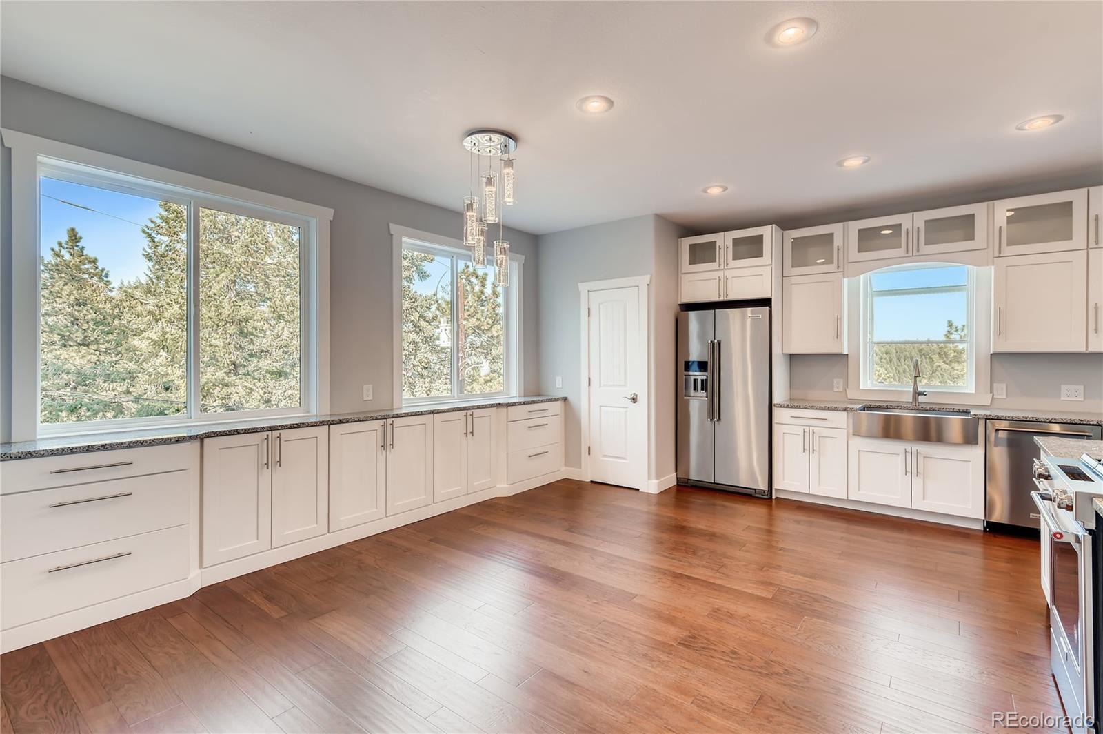 5967 High Drive Morrison, CO 80465 - Photo 14 of 38 a large white kitchen with wooden floors and white walls