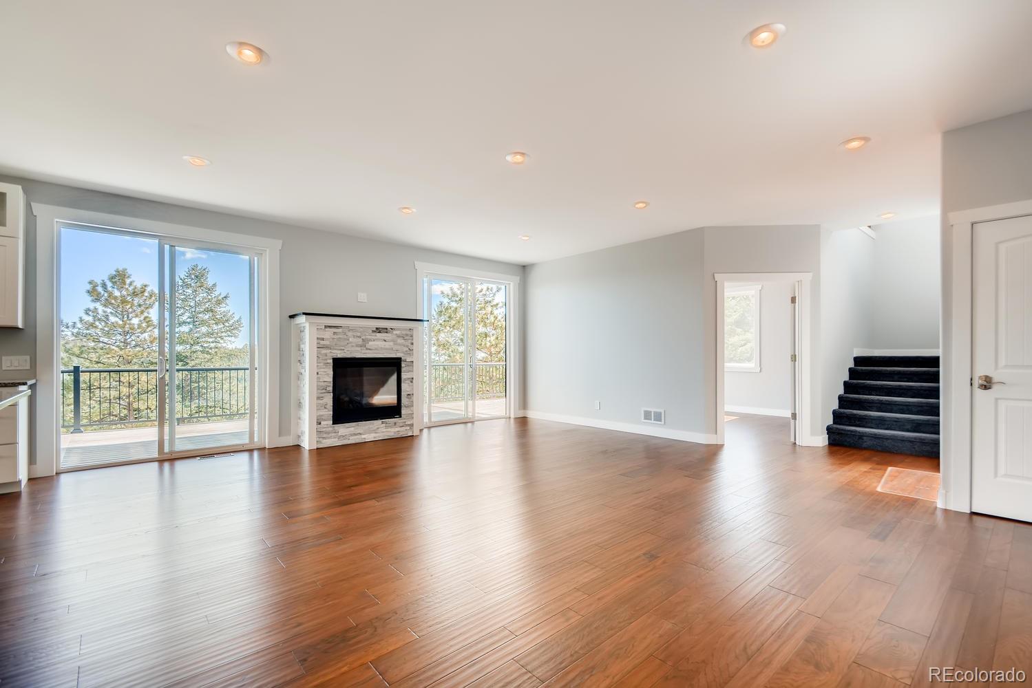 5967 High Drive Morrison, CO 80465 - Photo 17 of 38 a view of an empty room with wooden floor fireplace and a window