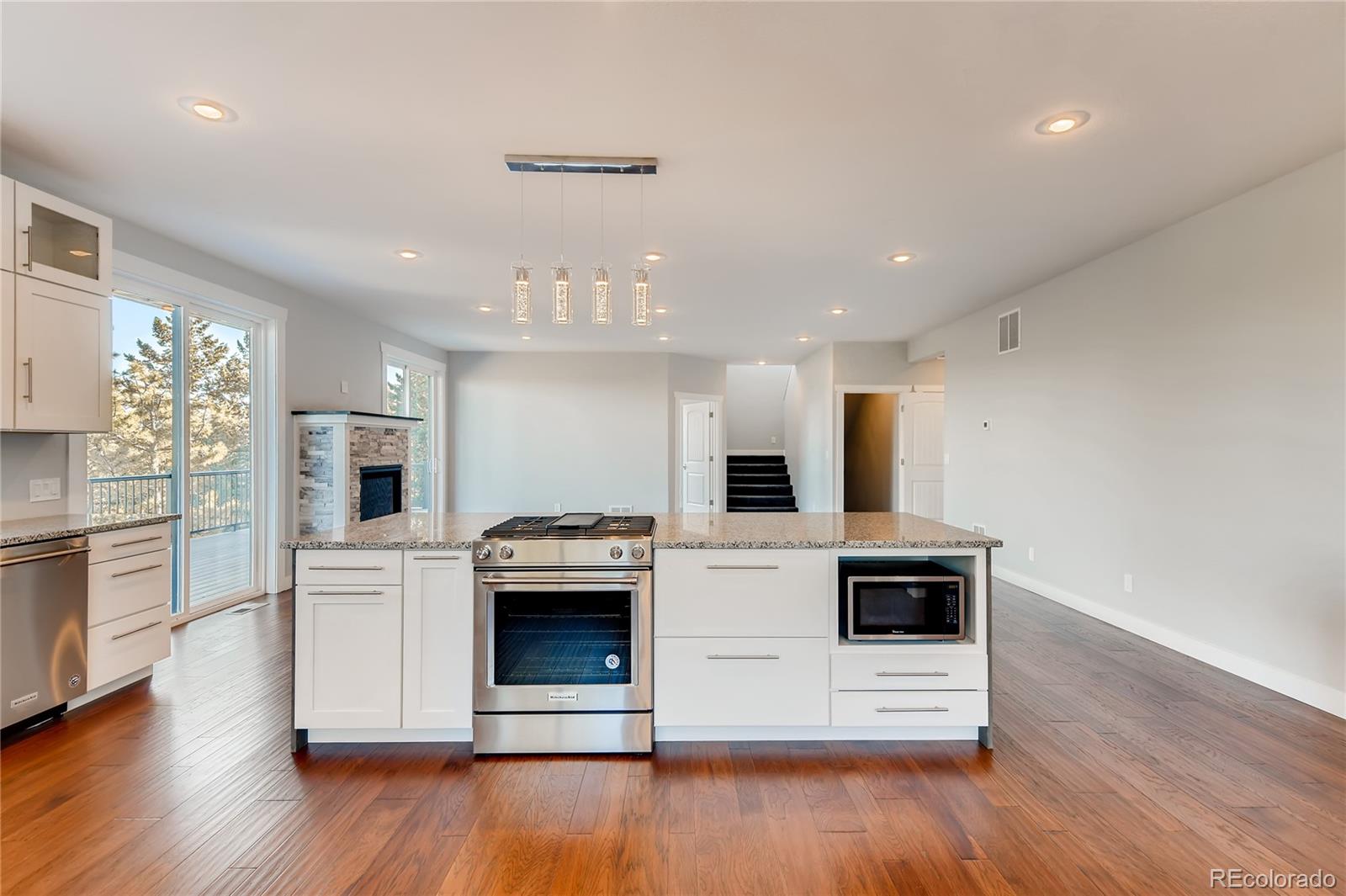 5967 High Drive Morrison, CO 80465 - Photo 7 of 38 a kitchen with kitchen island stainless steel appliances a stove top oven a refrigerator a sink and dishwasher with wooden floor