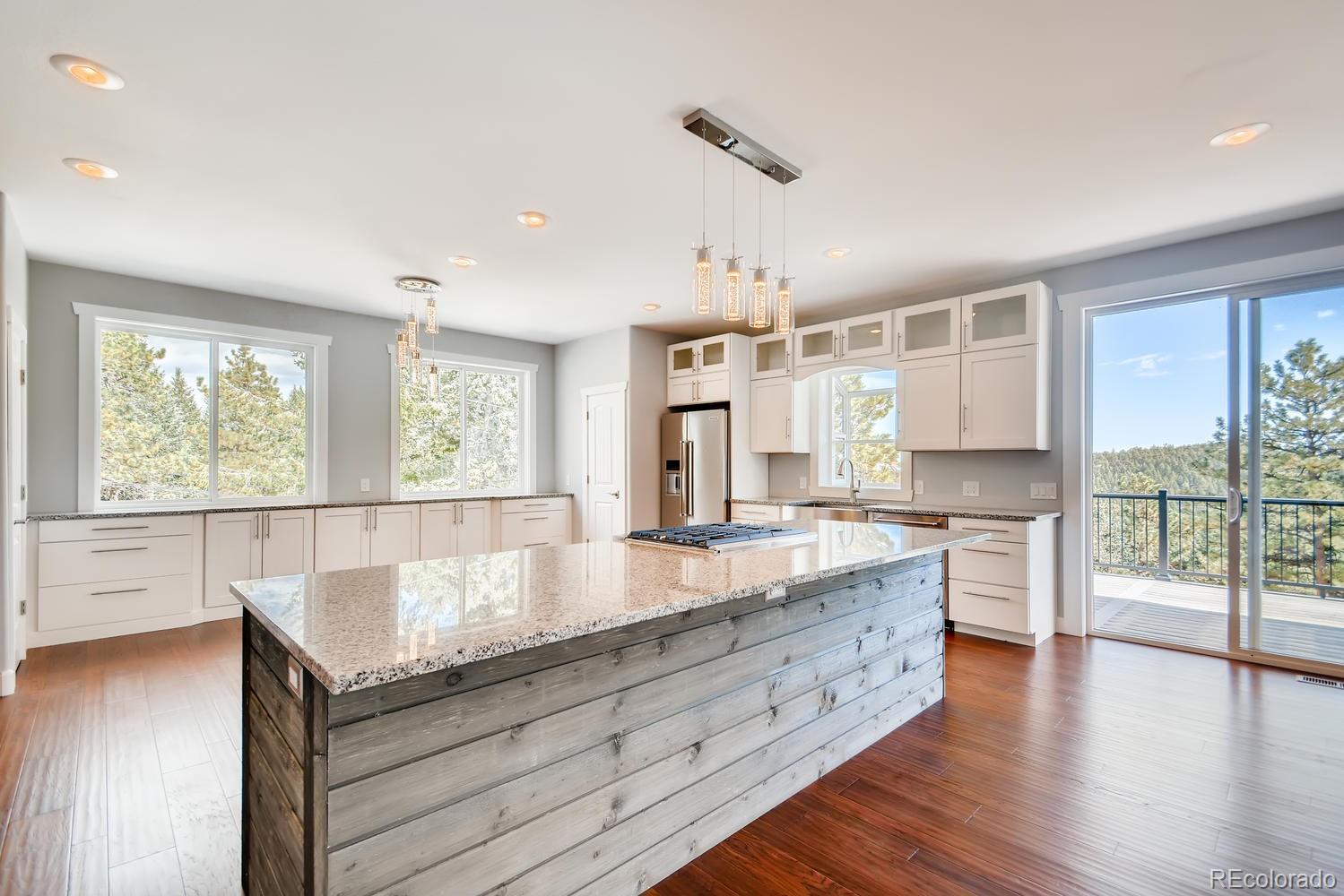 5967 High Drive Morrison, CO 80465 - Photo 10 of 38 a large kitchen with stainless steel appliances granite countertop a lot of counter space and wooden floors