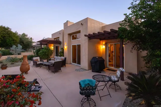 a view of a patio with couches table and chairs and potted plants
