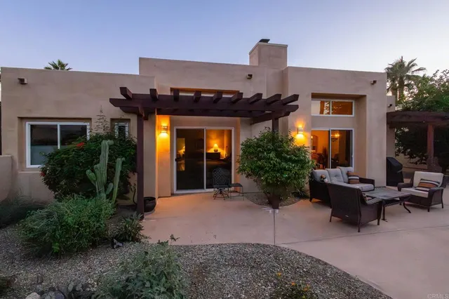 a view of a patio with couches table and chairs potted plants and palm tree