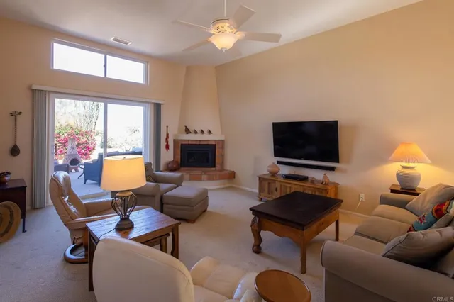 a living room with furniture a flat screen tv and a window
