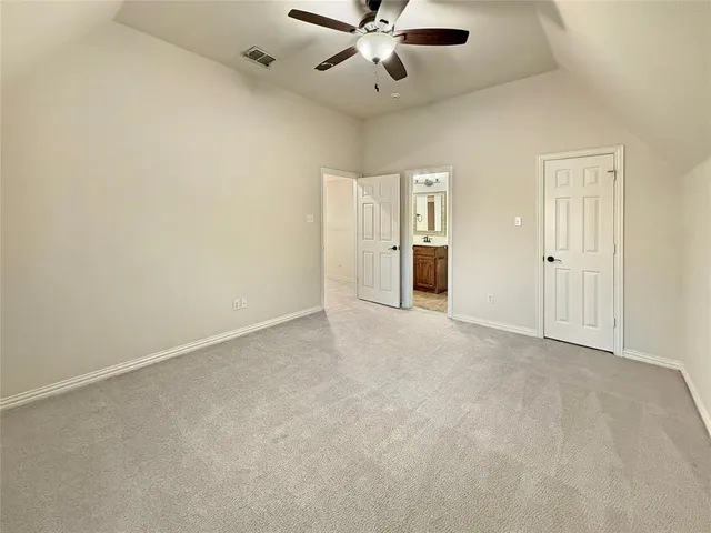 an empty room with closet and a chandelier fan