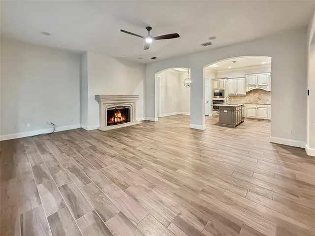 a view of empty room with a fireplace and wooden floor