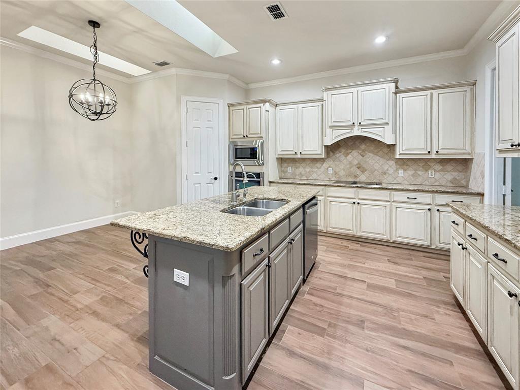 3779 Navarro Way Frisco, TX 75034 - Photo 5 of 17 a kitchen with kitchen island granite countertop a sink and a stove top oven