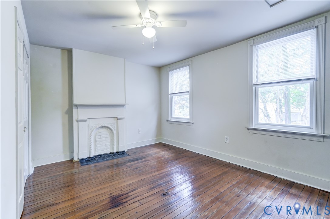 818 Spring Street Richmond, VA 23220 - Photo 17 of 28 an empty room with wooden floor chandelier and windows