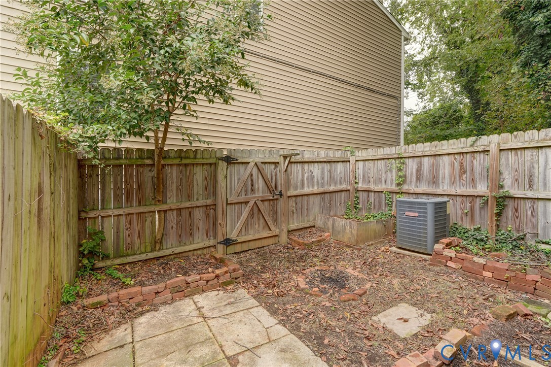 818 Spring Street Richmond, VA 23220 - Photo 24 of 28 a backyard of a house with plants and wooden fence