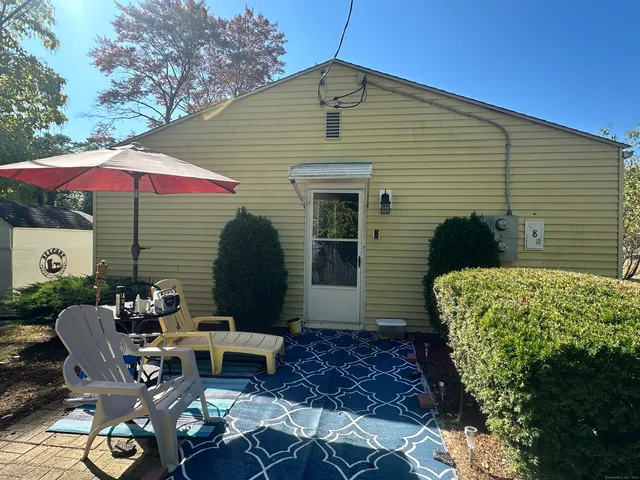 a balcony with table and chairs under an umbrella