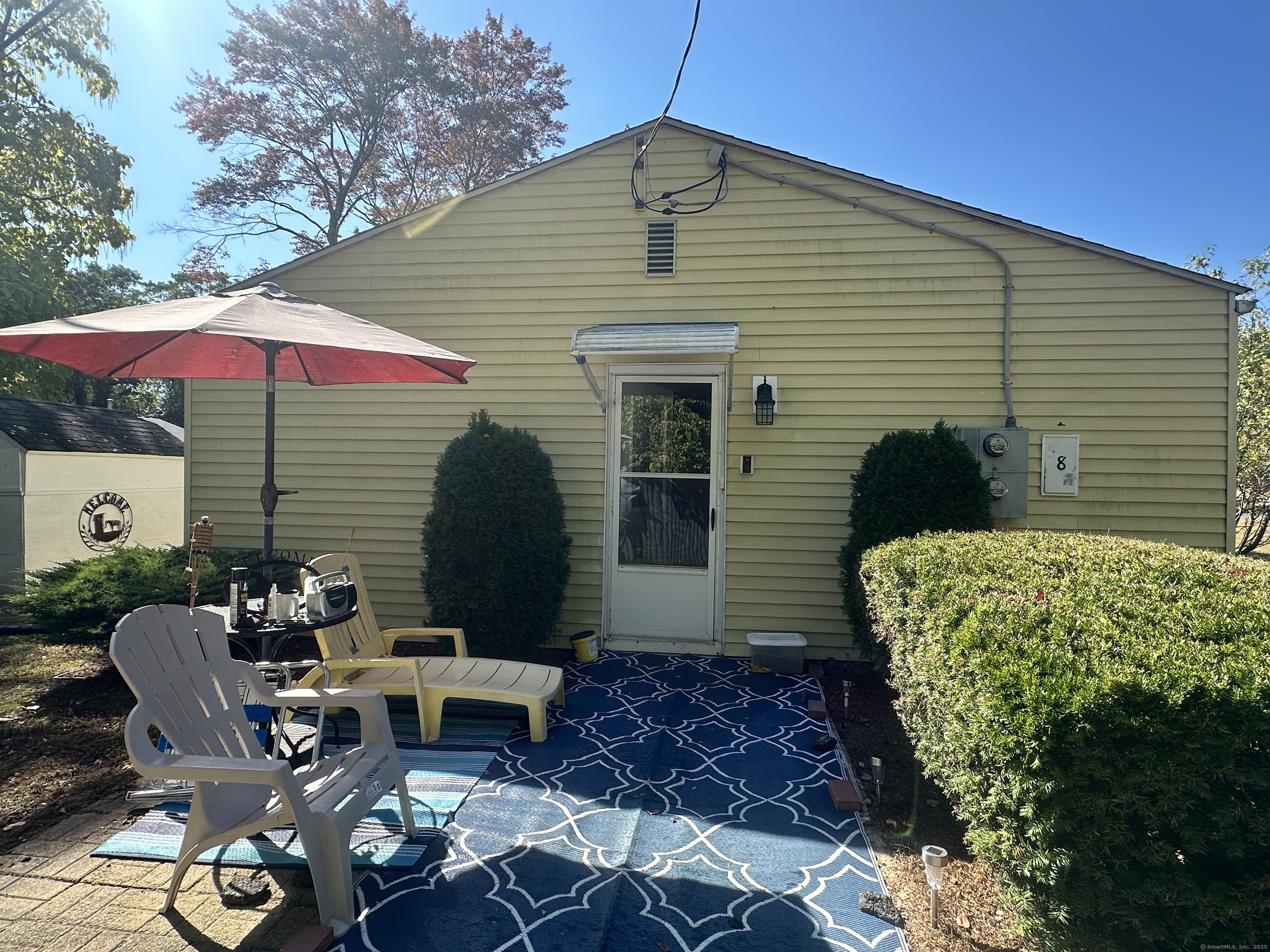 a balcony with table and chairs under an umbrella